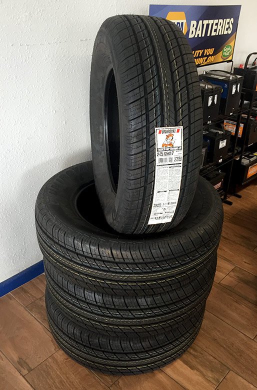 A stack of brand-new tires inside the CK Automotive shop, next to the battery rack